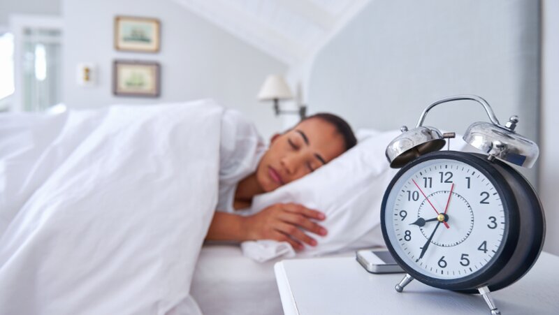 Una mujer que se recupera del cansancio durmiendo antes de las 10 de la noche