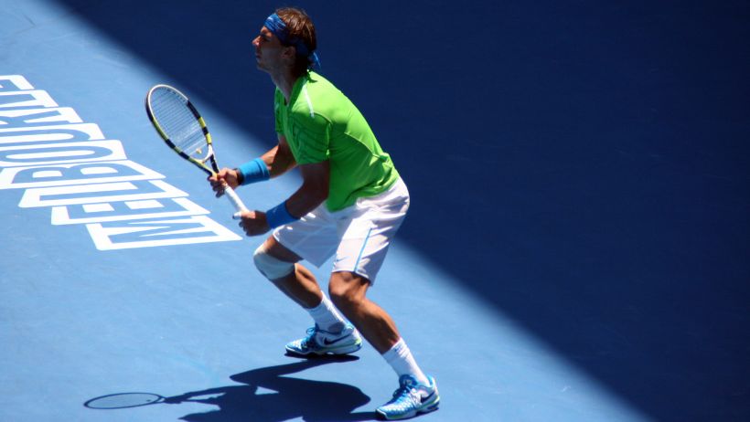 Un jugador de tenis profesional muy concentrado en el saque de respuesta